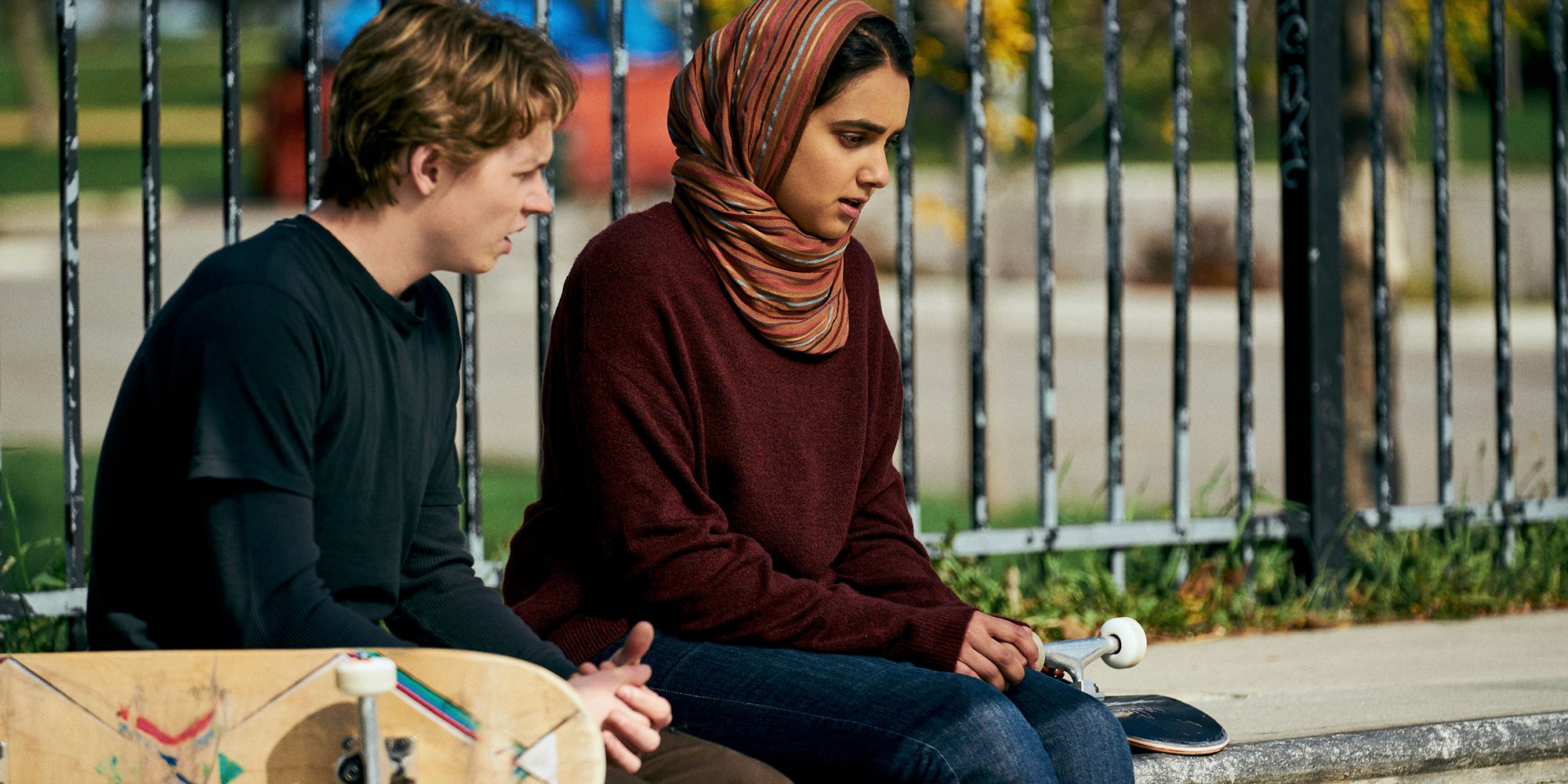 Geraldine Viswanathan and Jack Kilmer in 'Hala' in the park with two skateboards