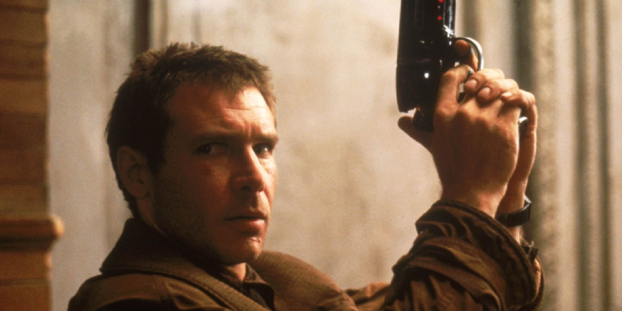 Harrison Ford dans le rôle de Rick Deckard tenant un pistolet dans Blade Runner. 