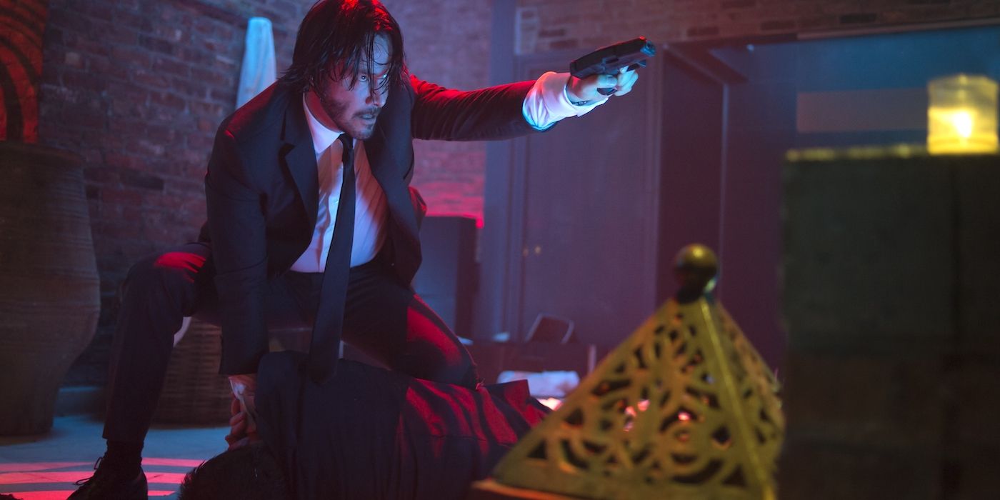 Keanu Reeves pointant une arme comme John Wick dans John Wick