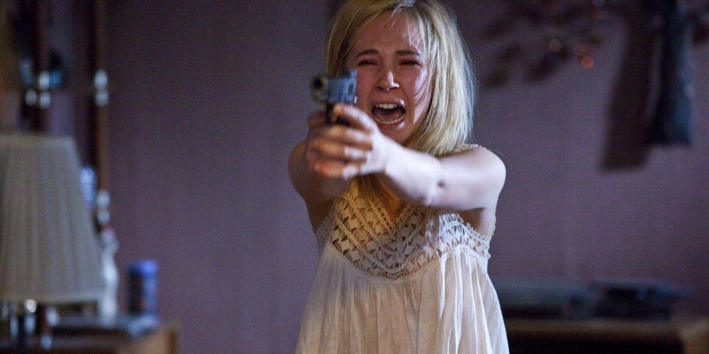 A screenshot of Juno Temple holding a gun and screaming in the film Killer Joe