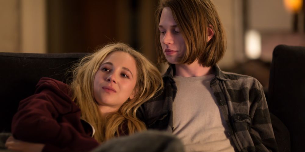 A screenshot of Juno Temple and Jack Kilmer sitting on the couch together in Len and Company