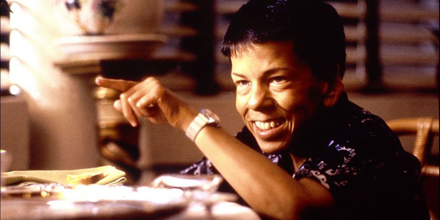 Billy Kwan souriant en fumant un cigare dans The Year of Living Dangerously