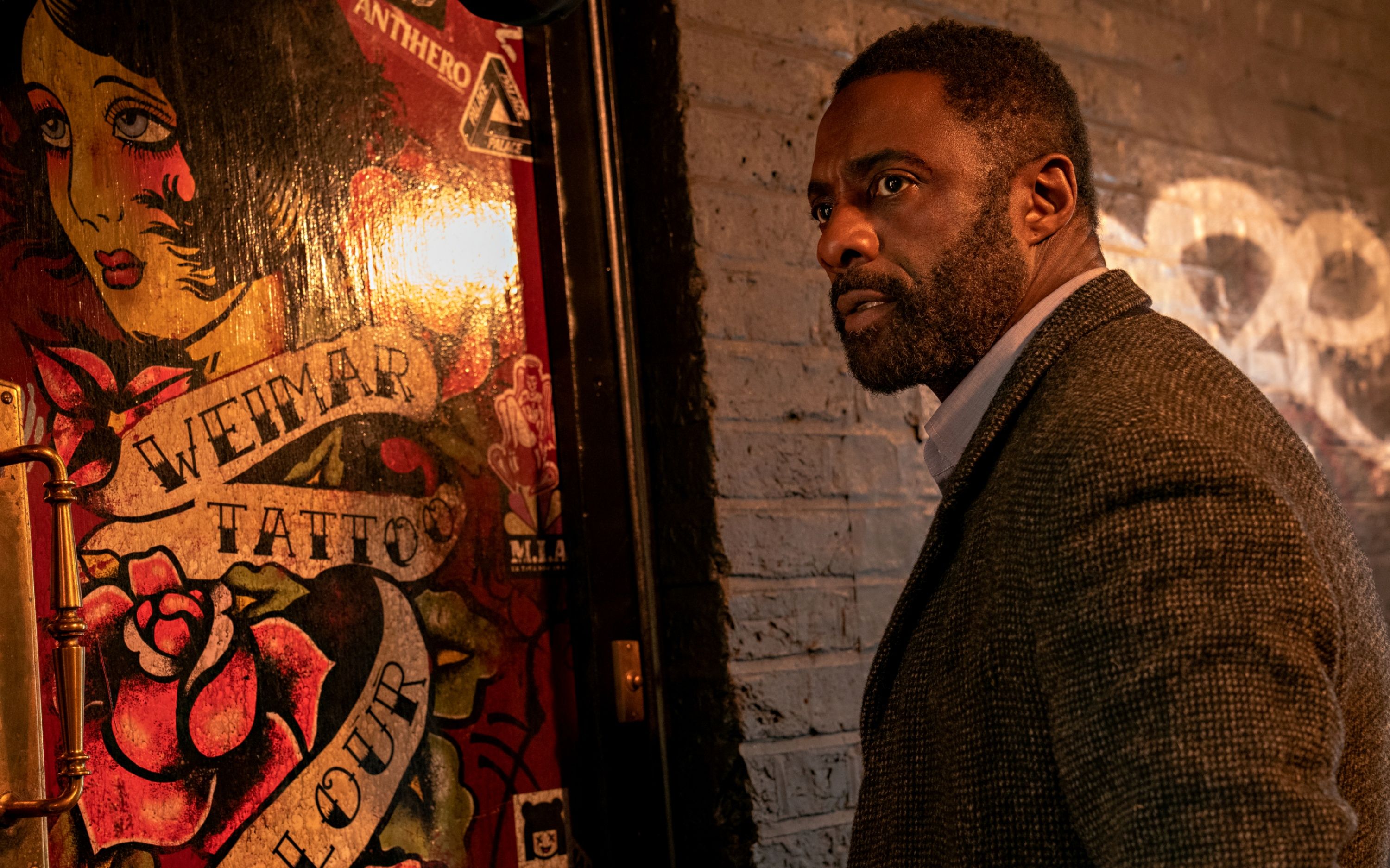 Idris Elba as DCI John Luther at the tattoo shop/exhibition in Luther: Fallen Sun