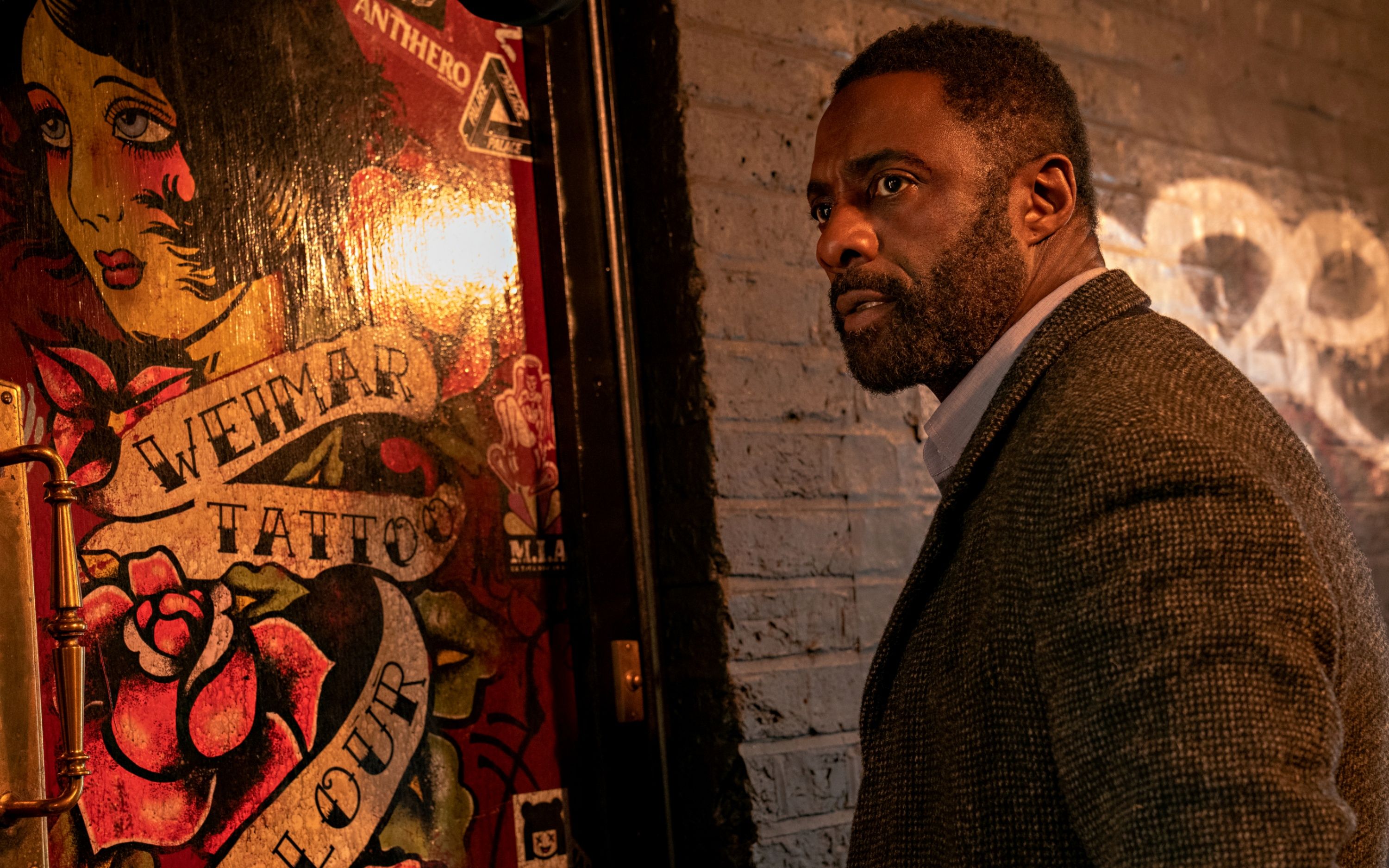 Idris Elba is DCI John Luther at the tattoo shop / peep show in Luther: The Fallen Sun