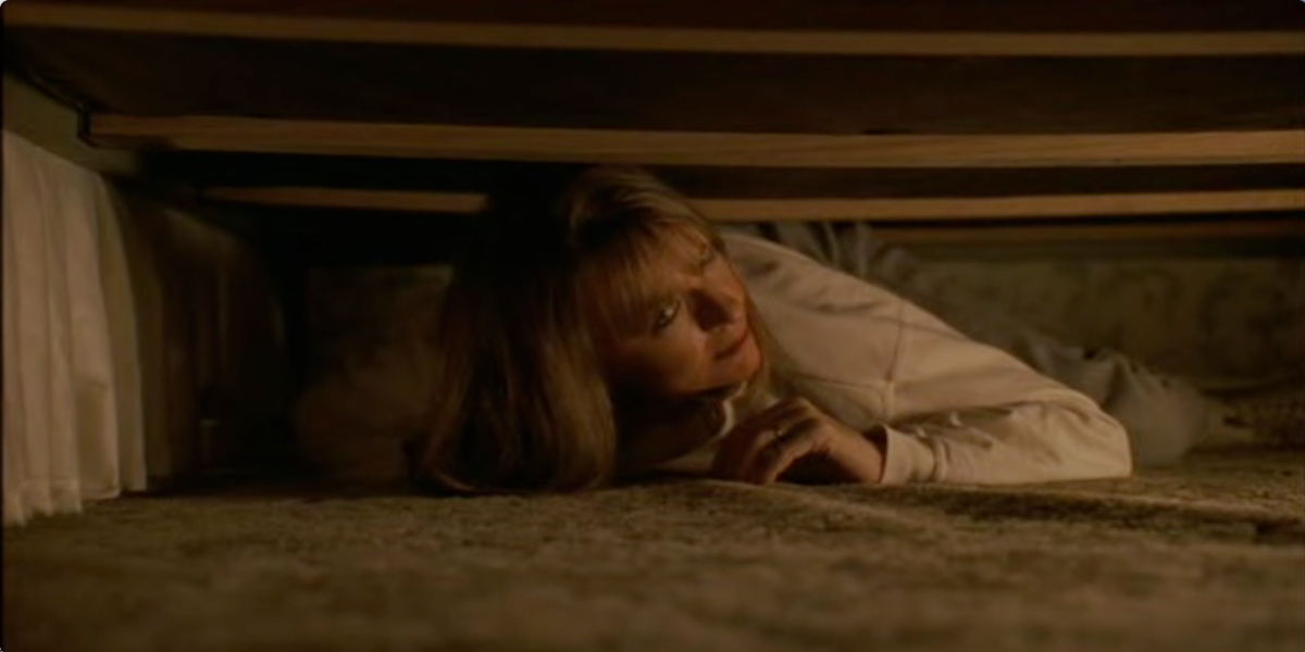 Diane Keaton as Carol Lipton hiding under a bed in Manhattan Murder Mystery.