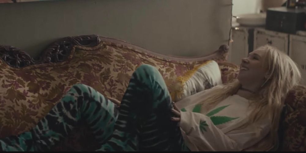 Capture d'écran de Juno Temple allongée sur le canapé dans le film Meadowland (2015)