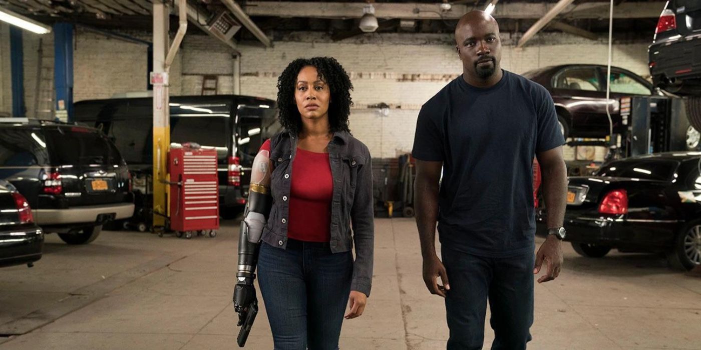Simone Missick als Misty Knight mit einer Waffe neben Mike Colter als Luke Cage in einer Garage in Netflix Marvels Luke Cage