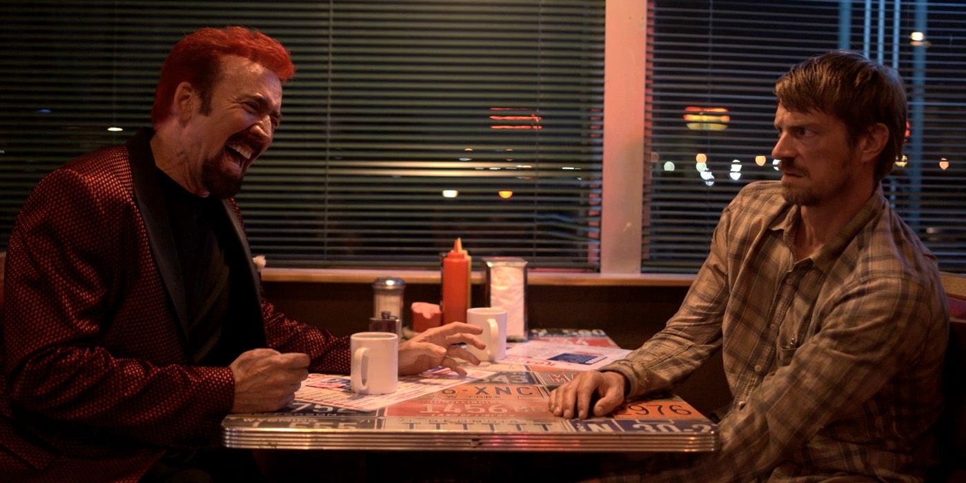 Nicolas Cage and Joel Kinnaman at a dinner party in Sympathy for the Devil