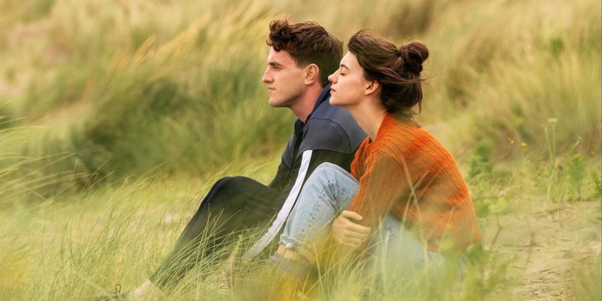 Daisy Edgar Jones and Paul Mescal sitting on a field in Normal People