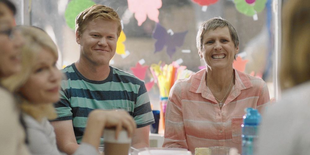 Jesse Plemons and Molly Shannon sitting together at a table at a party in Other People (2016)