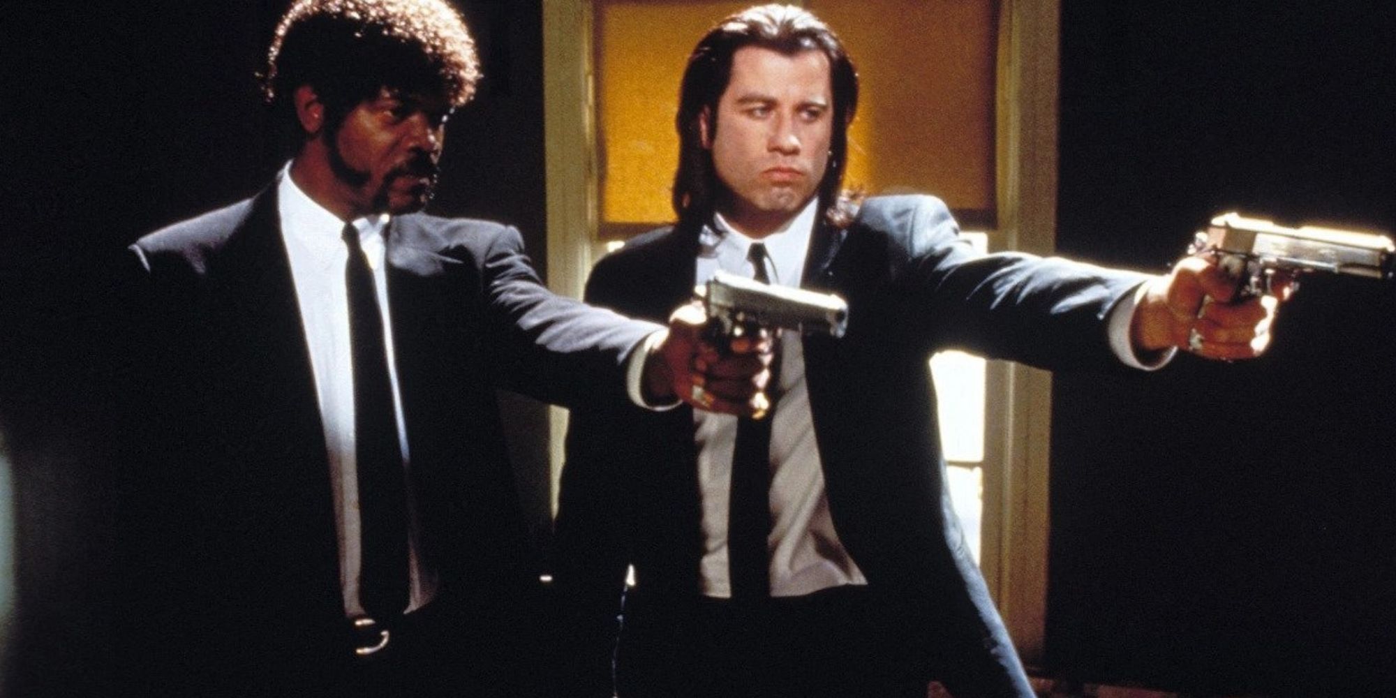 Samuel L. Jackson and John Travolta in suits holding guns in a scene from Pulp Fiction.