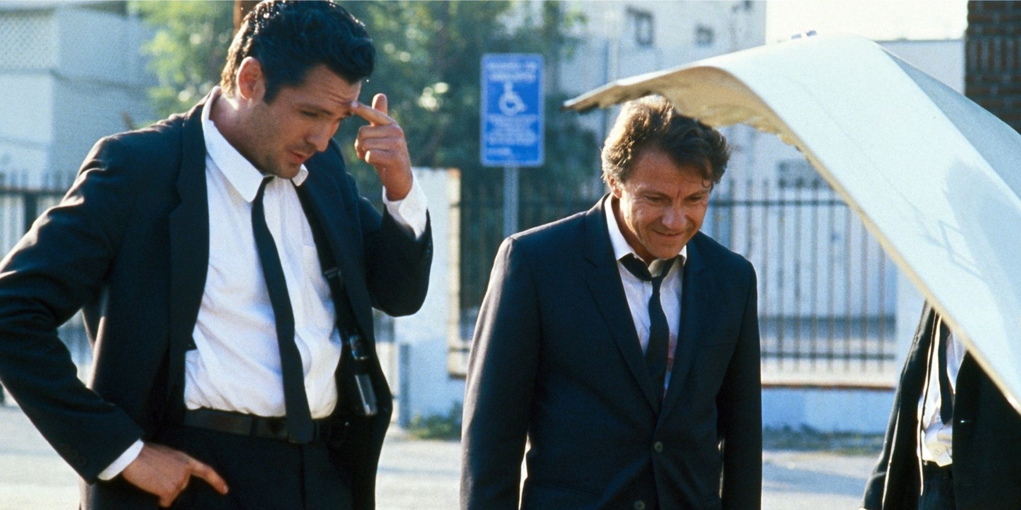 Two men in suits staring at the boot of a car in &lsquo;Reservoir Dogs&rsquo;