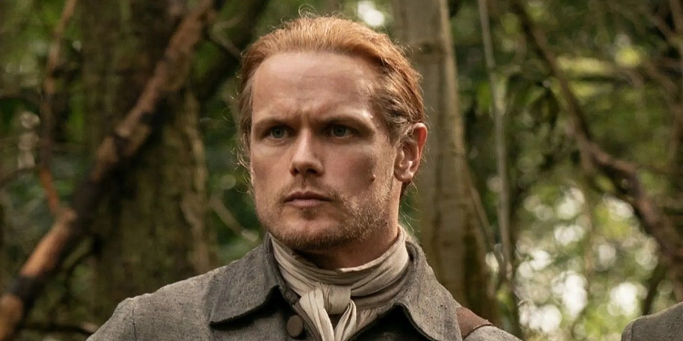 Sam Heughan as Jamie Fraser wearing a dark grey suit in 'Outlander.'