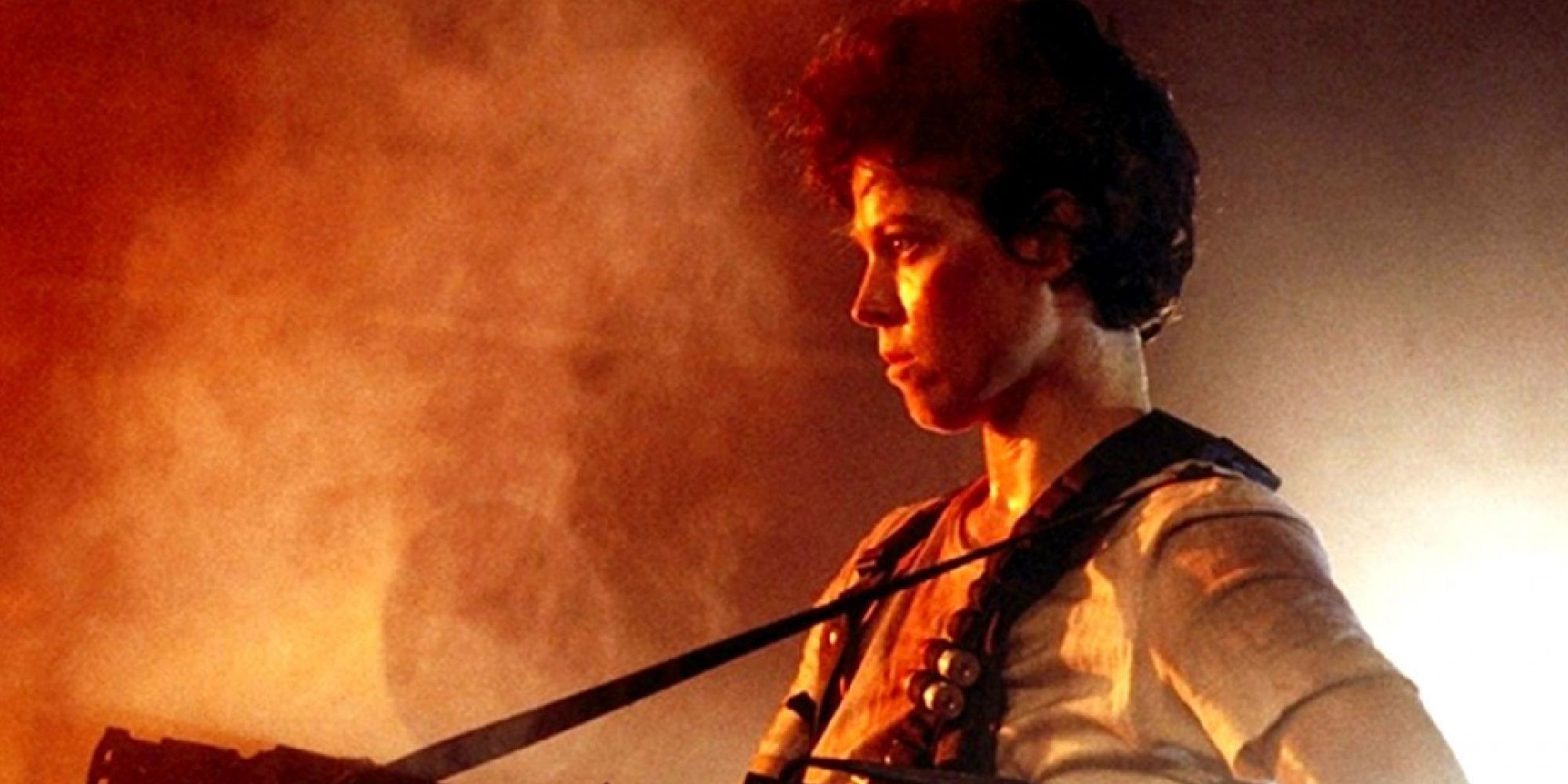 Sigourney Weaver as Ellen Ripley holding a gun in Aliens.