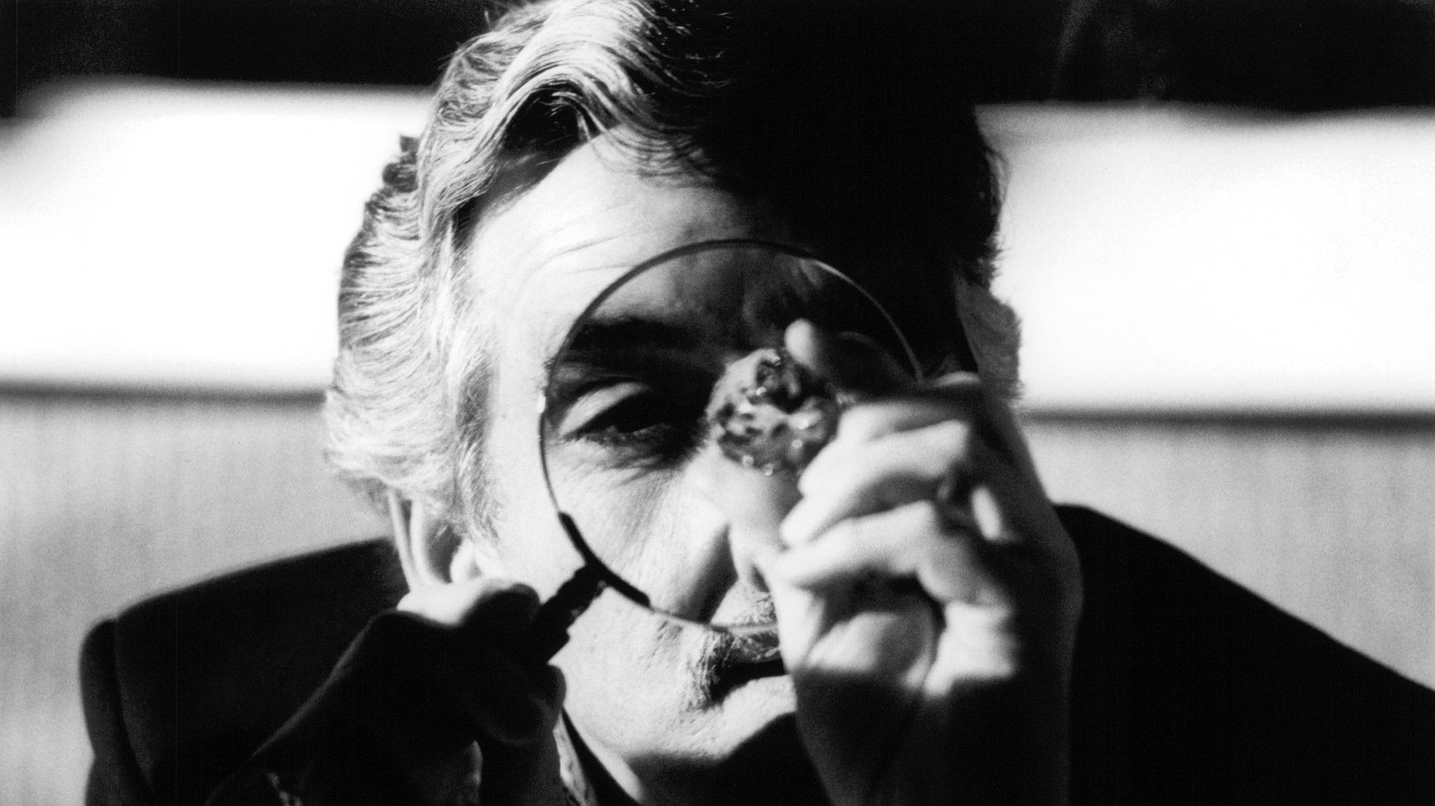 Dennis Farina looking at a diamond with a magnifying glass in Snatch. 