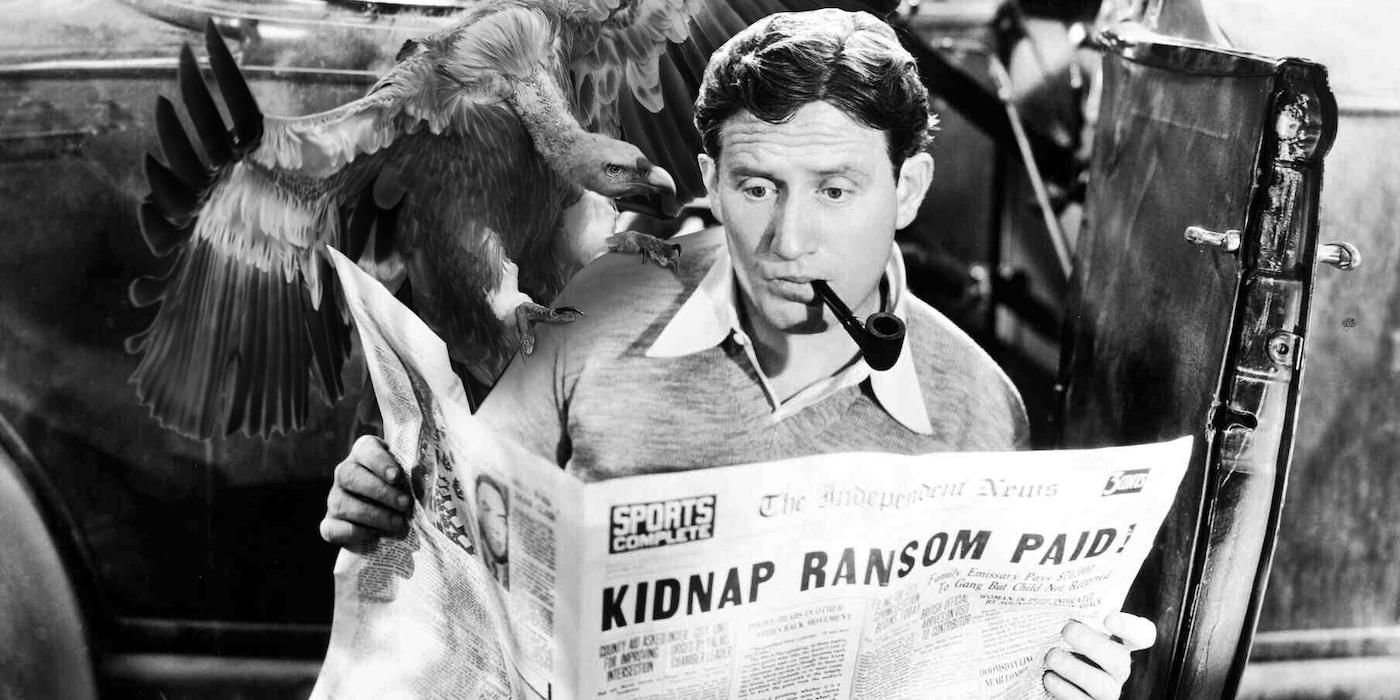 Spencer Tracy reading a newspaper smoking a pipe in Fury