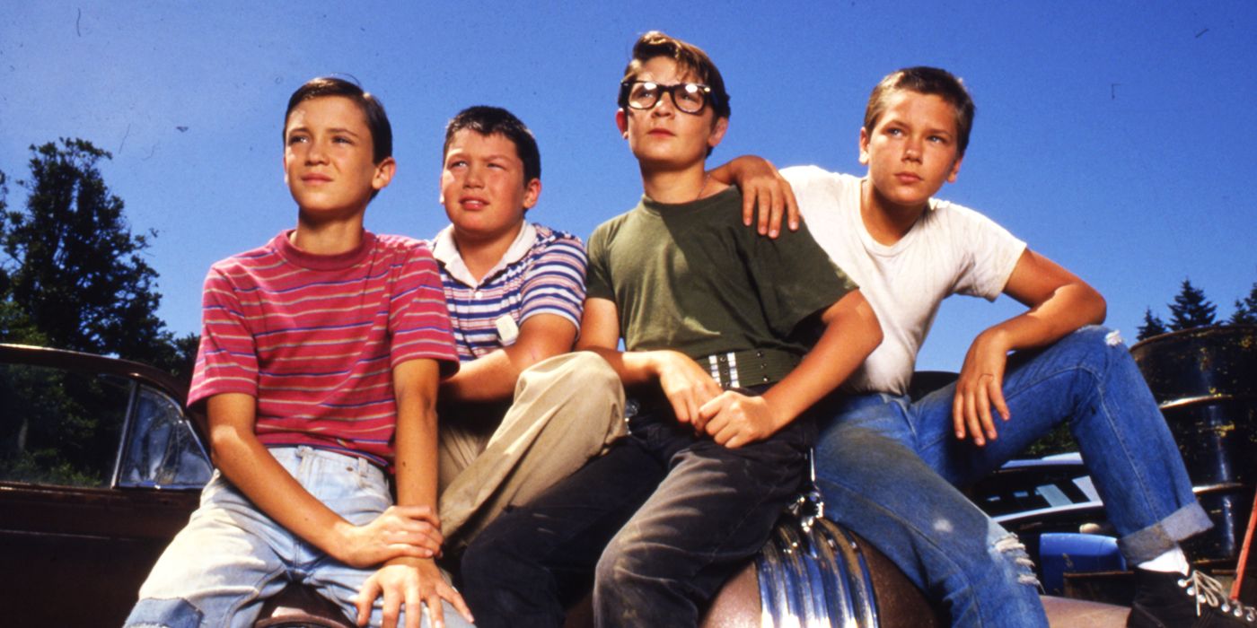 The cast of Stand By Me sitting together and looking to the distance.