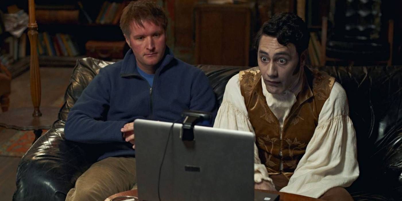 Stuart Rutherford and Taika Waititi sitting together and looking into a laptop camera in What We Do in the Shadows