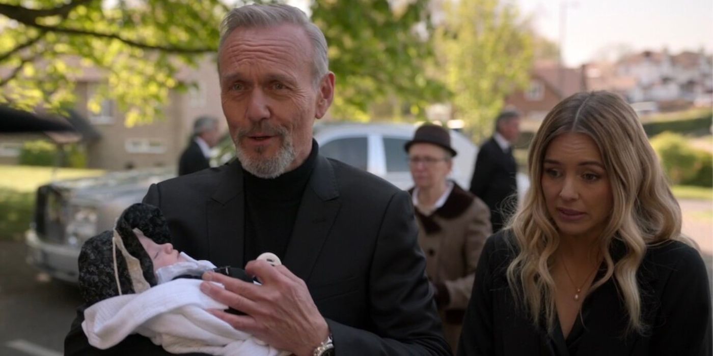 Keeley Hazell as Bex and Anthony Head as Rupert Mannion holding a baby in Ted Lasso Season 2