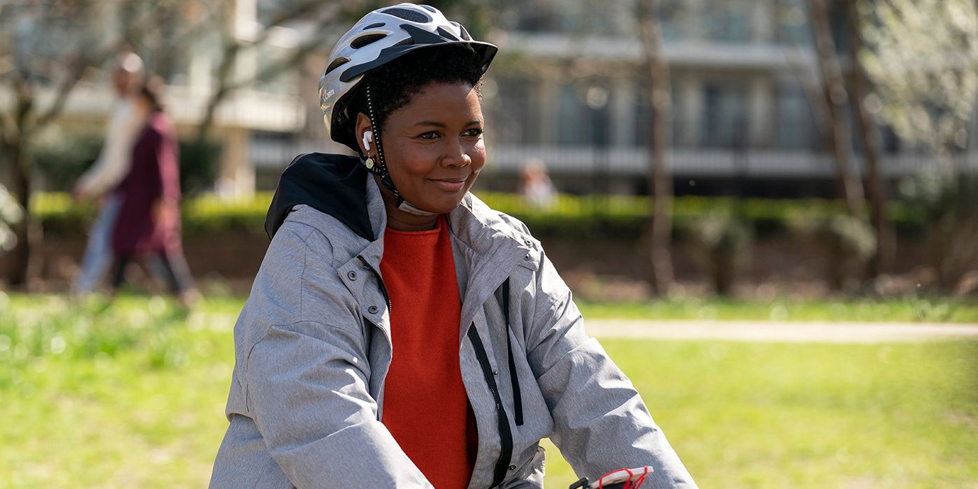 Sharon terapis dari Ted Lasso dengan helm sambil tersenyum dan mengendarai sepeda.