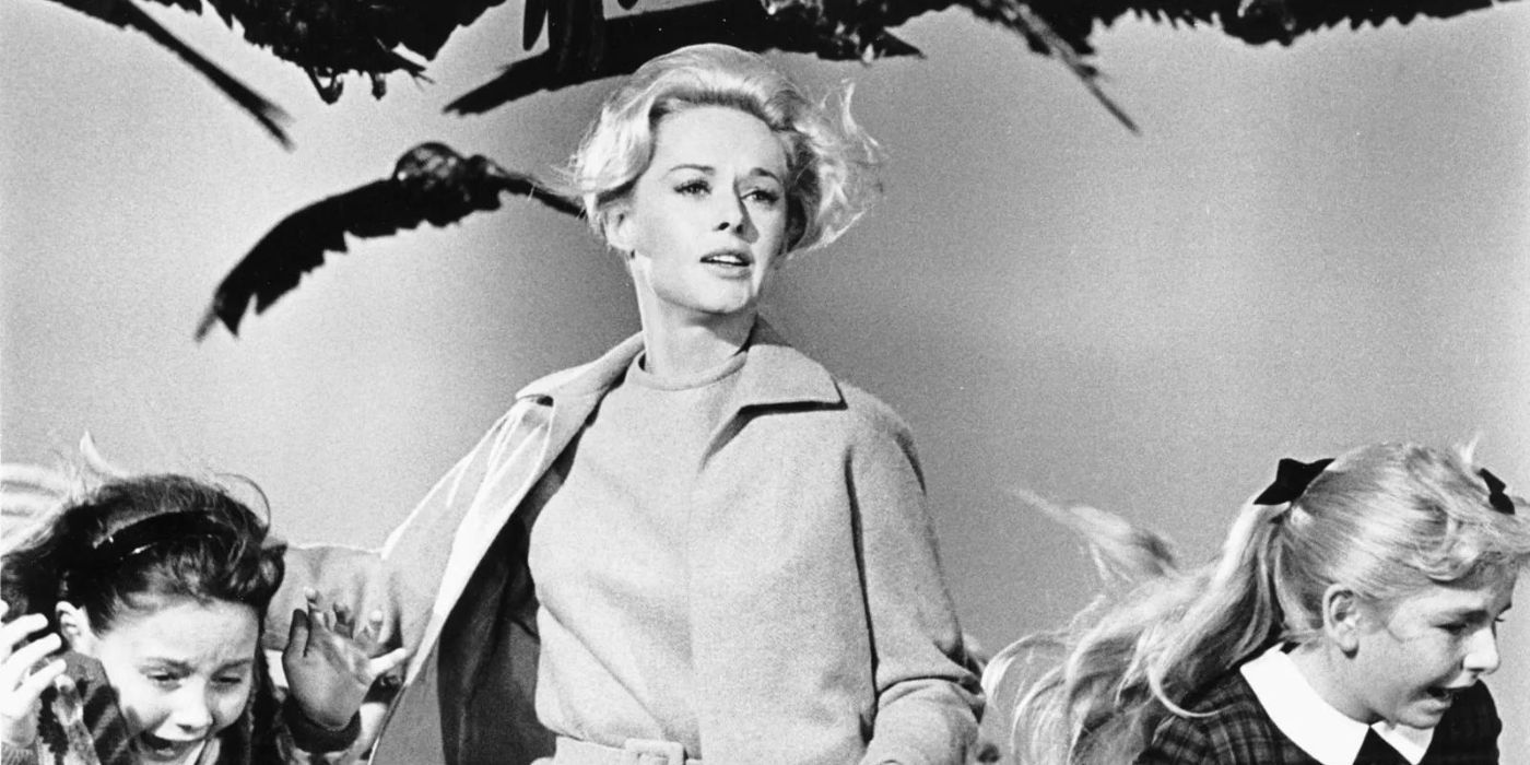 Melanie, played by Tippi Hedren, running with two little girls away from a swarm of attacking birds in Alfred Hitchcock's The Birds