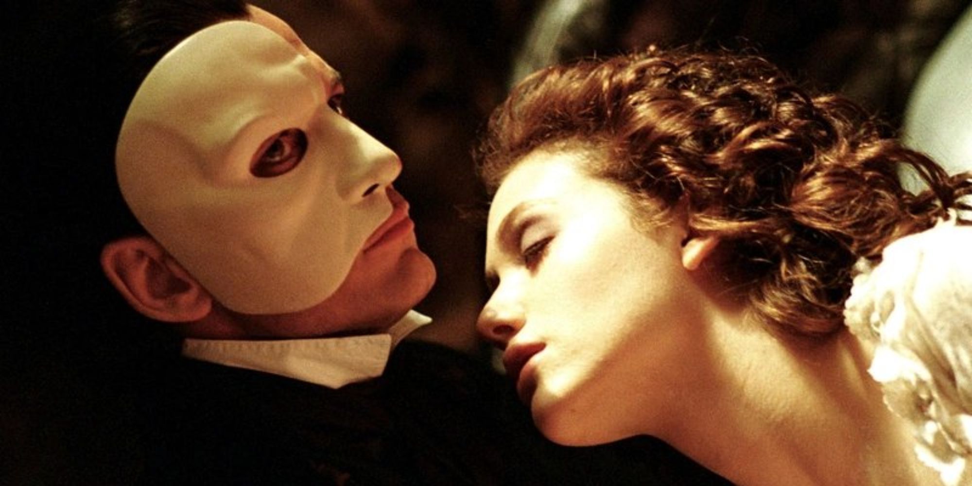 Uma sonolenta Emmy Rossum apoiada em Gerard Butler em O Fantasma da Ópera (2004)