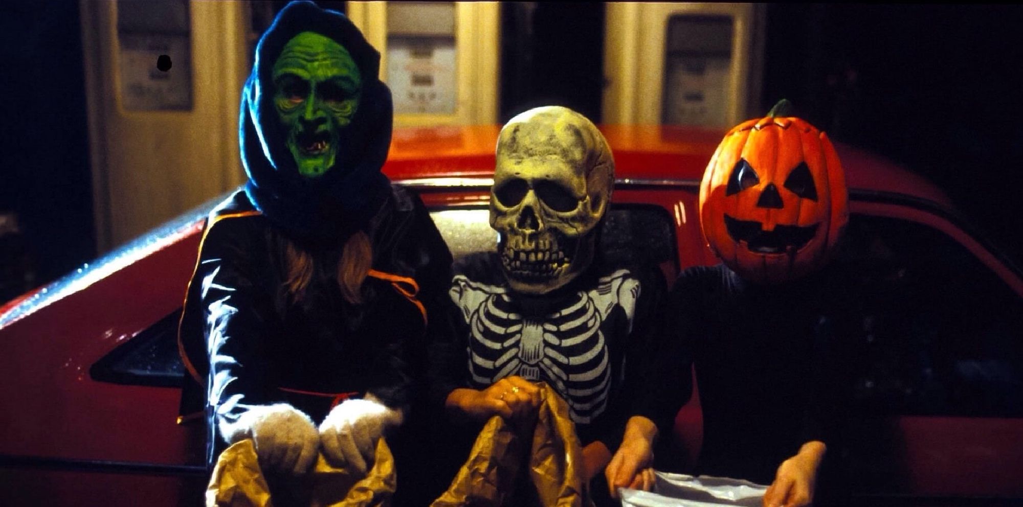 Trois personnes portant des masques et s'adonnant à la chasse aux bonbons dans Halloween III : Season of the Witch