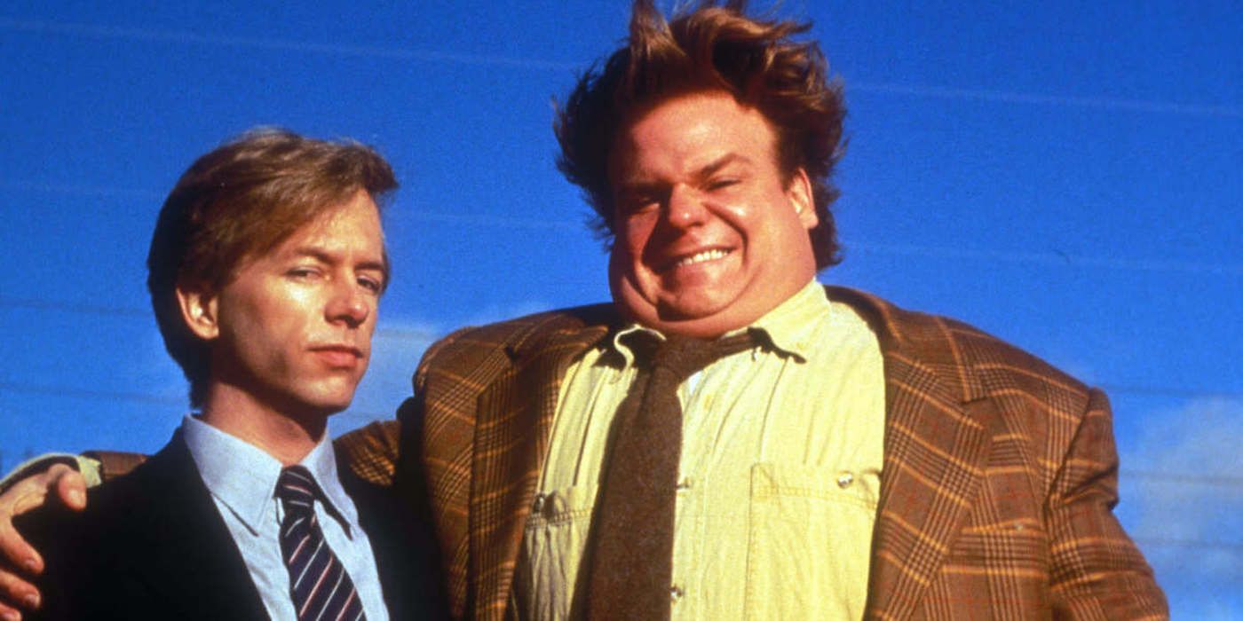 David Spade and Chris Farley in Tommy Boy, Farley smiling with his arm around Spade, Spade looking unimpressed.