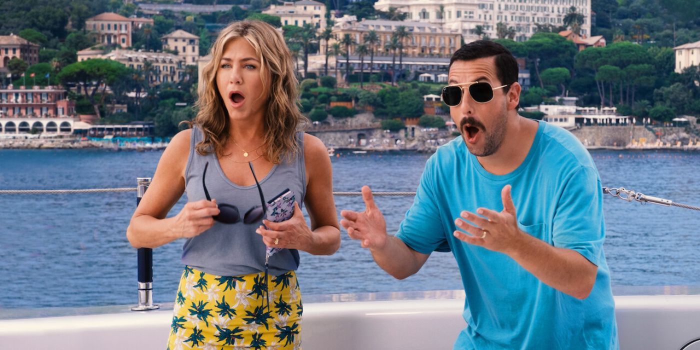 Adam Sandler dan Jennifer Aniston terlihat kaget saat mereka berdiri di kapal pesiar di Misteri Pembunuhan