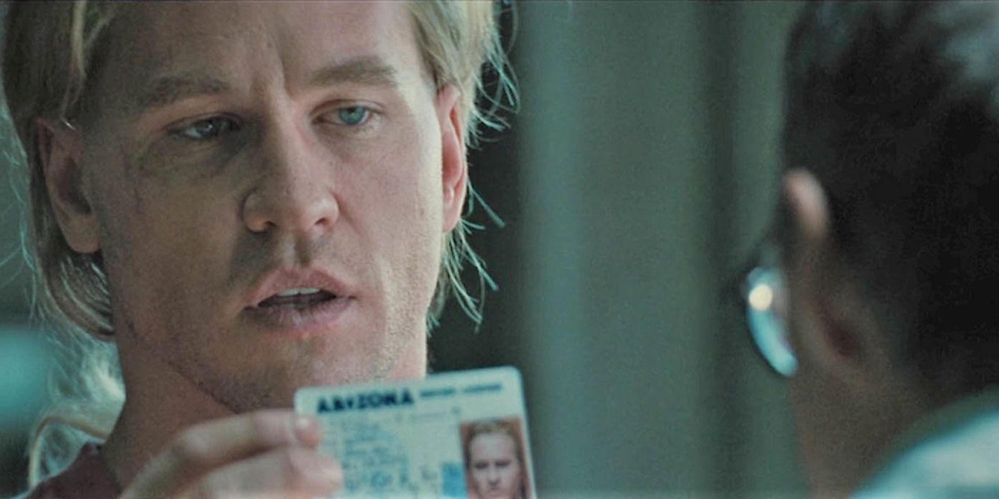 Val Kilmer in 'Heat' showing a man with glasses a piece of ID