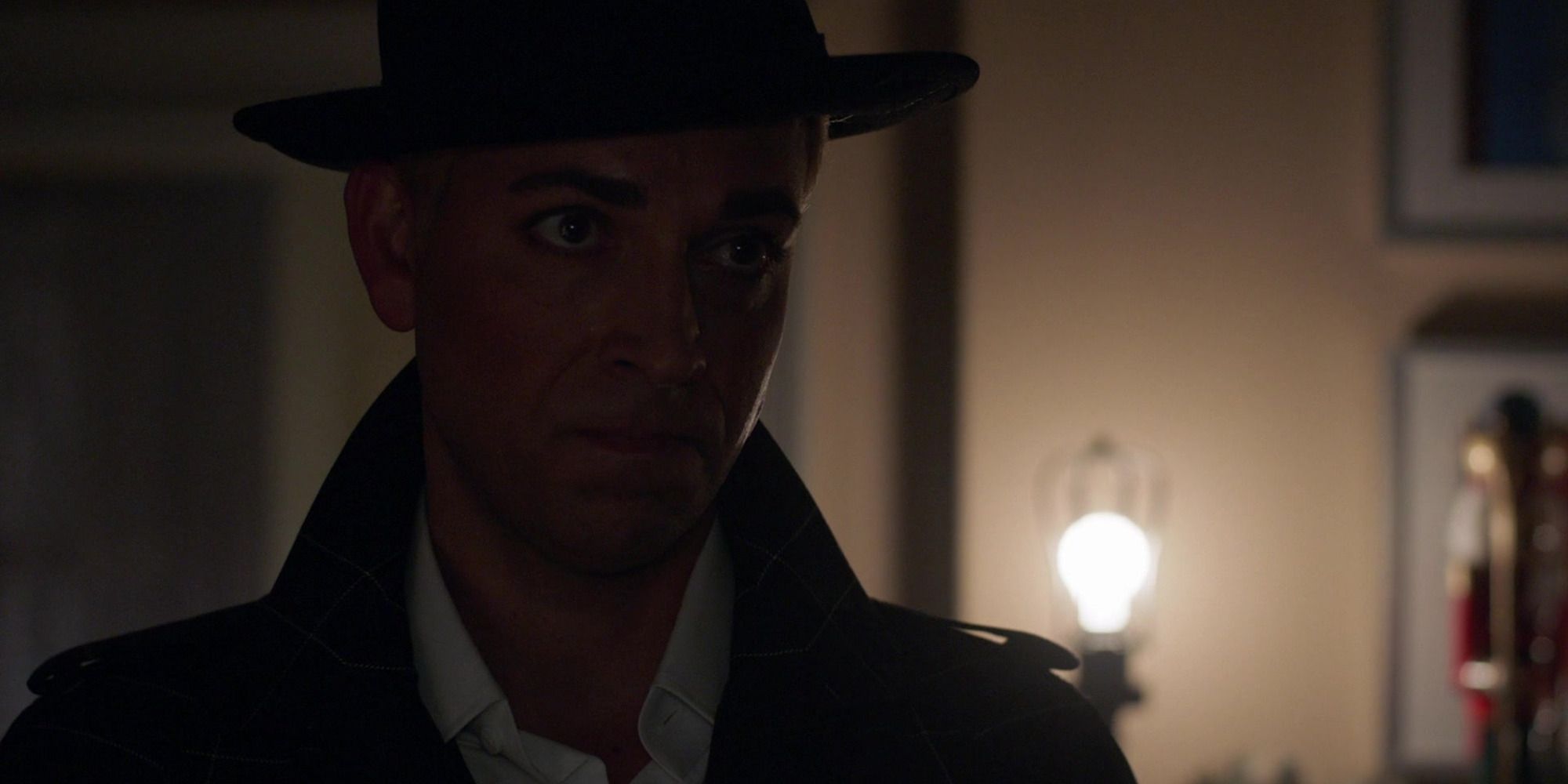Zachary Levi in 'Psych: The Movie', wearing a black hat in a dimly lit room