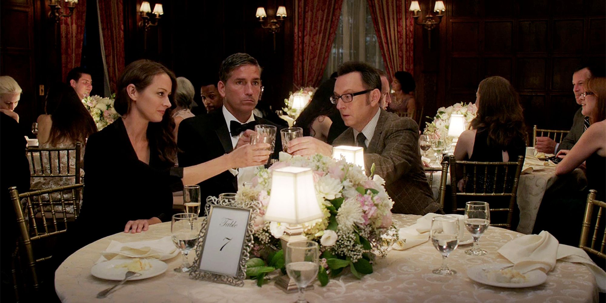 Amy Acker, Jim Caviezel, and Michael Emerson at a fancy dinner table in 'Person of Interest'