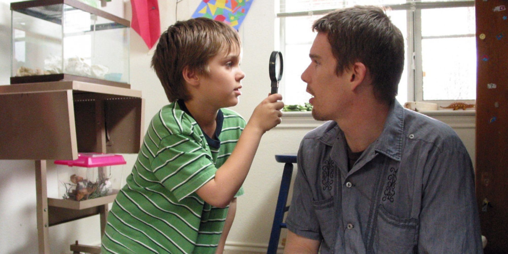 Mason Jr. looking at Mason Sr's face with a magnifying glass in Boyhood (2014) (1)
