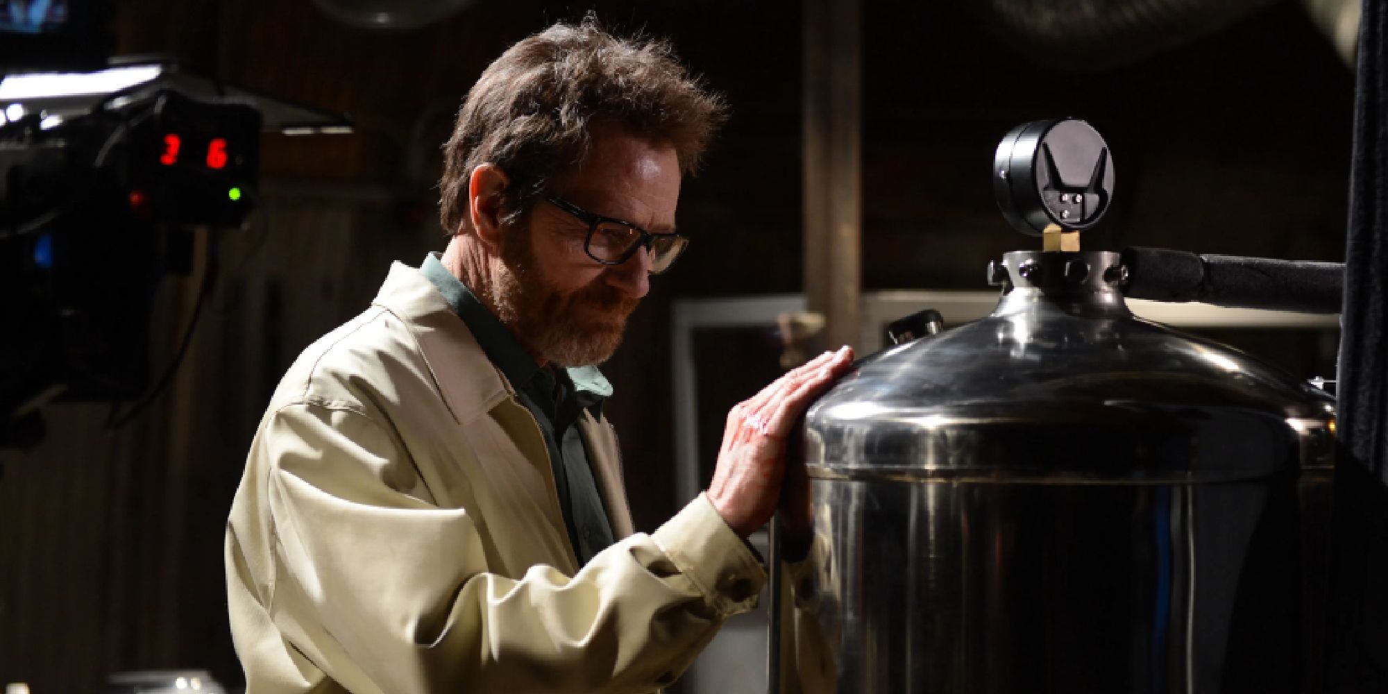 Bryan Cranston as Walter White standing in front of and touching a machine in Breaking Bad