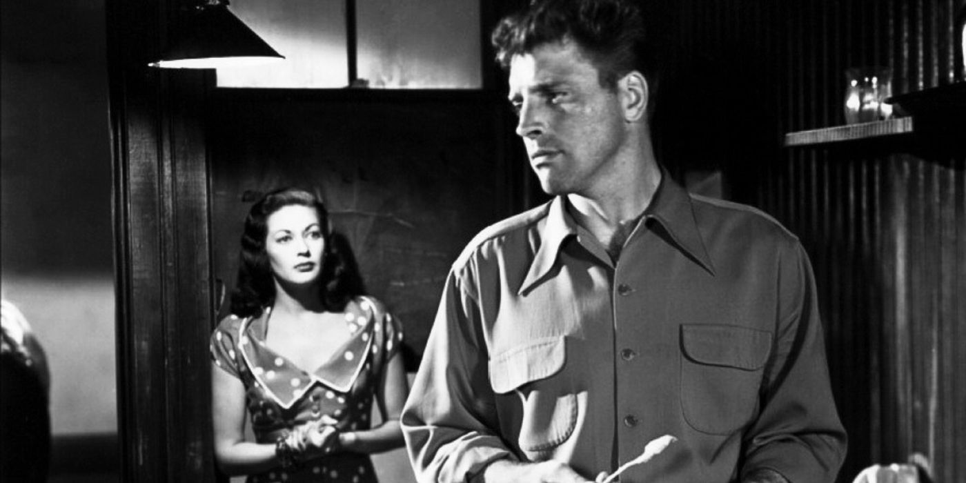 Burt Lancaster standing in front of Yvonne de Carlo in Criss-Cross