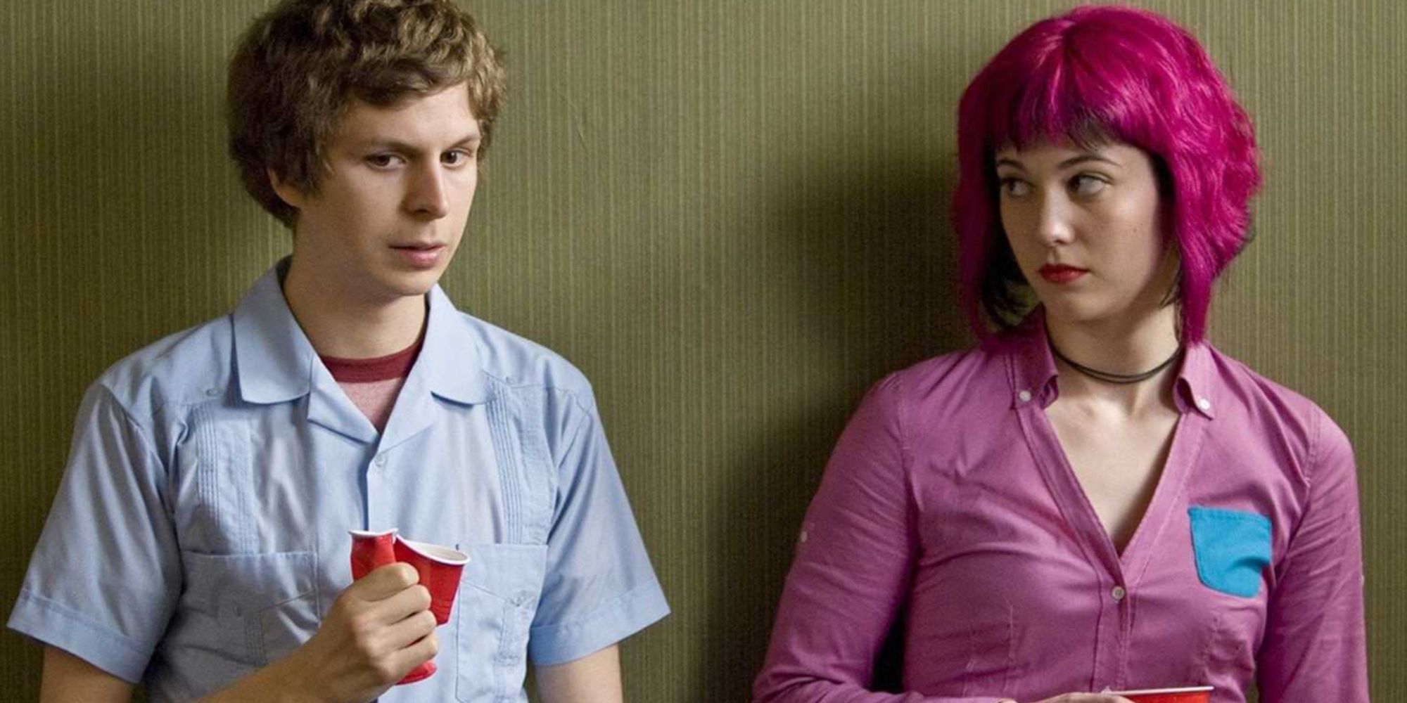 Michael Cera as Scott Pilgrim crushing a cup and Mary Elizabeth Winstead looking towards him while standing against a wall in Scott Pilgrim vs The World