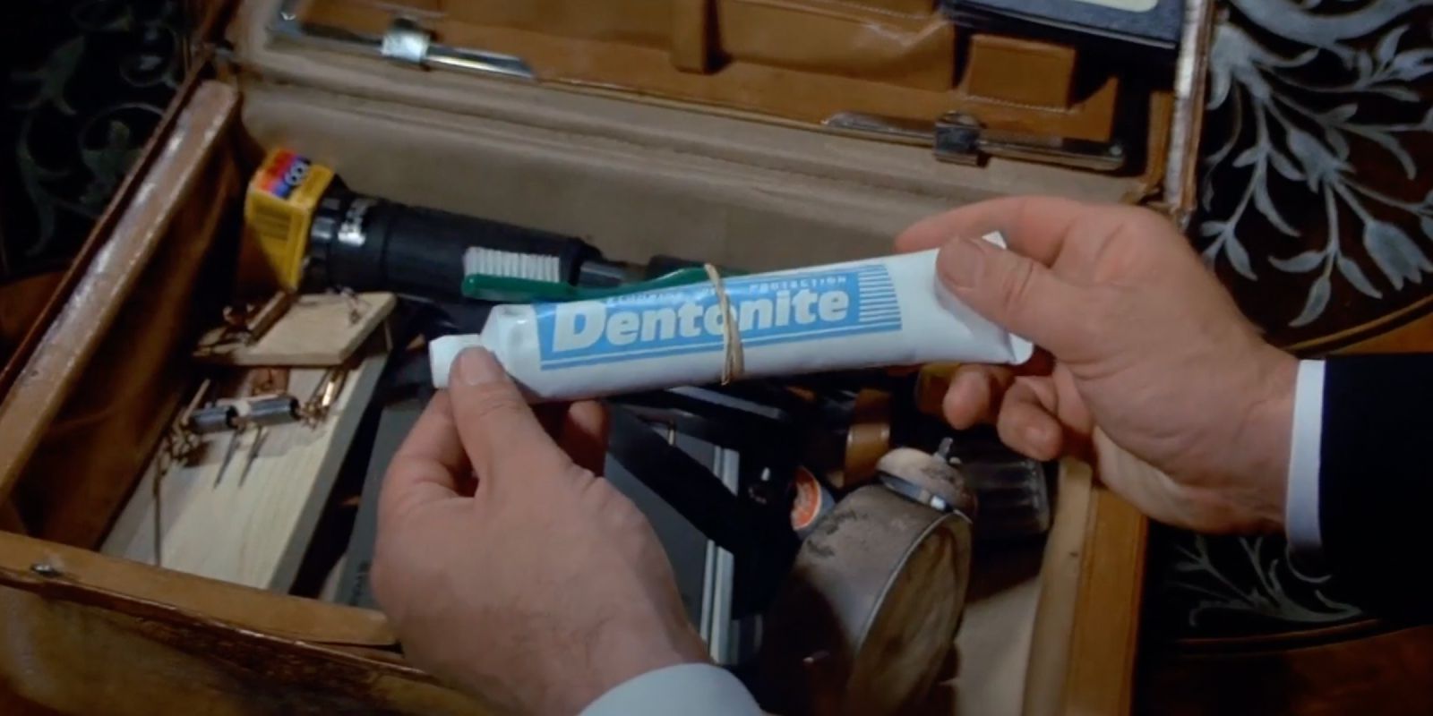 James Bond looks at the Dentonite toothpaste explosive gadget ahead of Q's case of device. 
