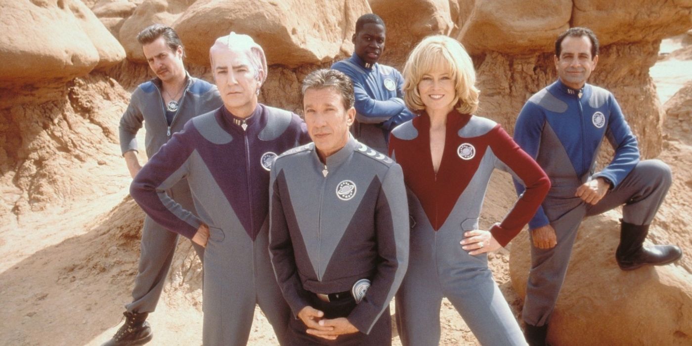 The cast of Galaxy Quest poses in their uniforms in a rocky desert.