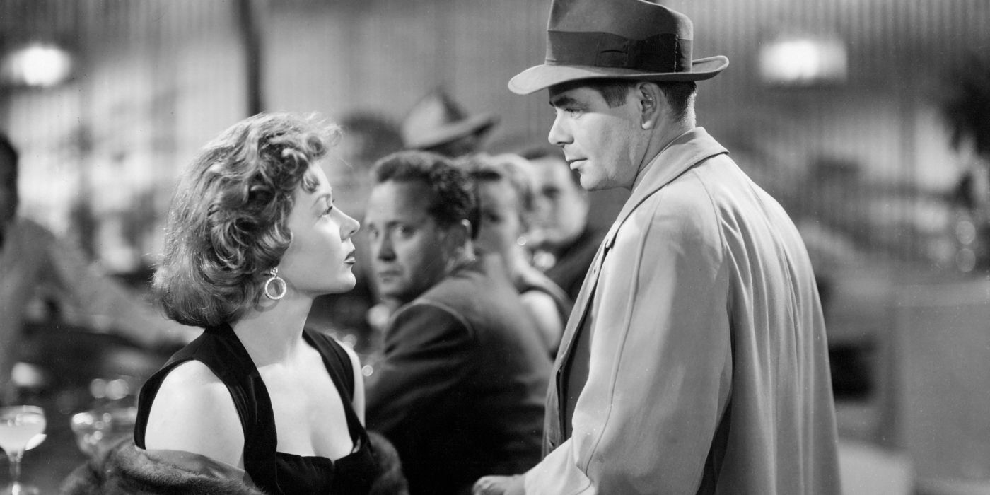 Glenn Ford looking at Gloria Grahame sitting in The Big Heat