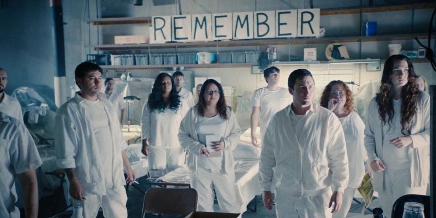 The guilty remnant cult standing in front of a sign that says &lsquo;Remember&rsquo; in The Leftovers
