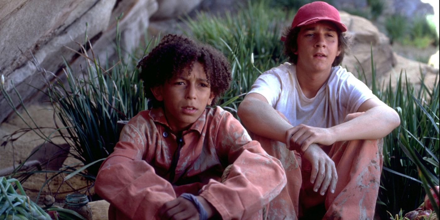 Shia LaBeouf as Stanley and Khleo Thomas as Hector sitting in the grass in Disney's Holes.