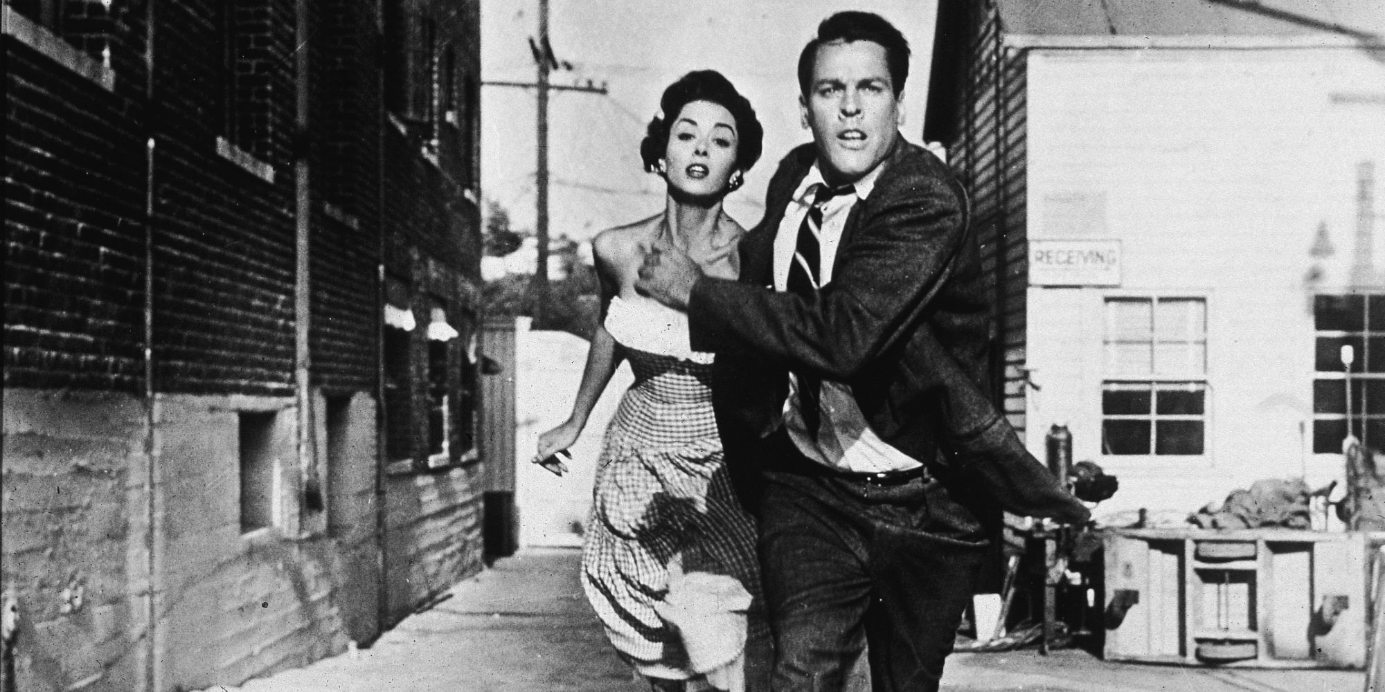 A couple running down a street in Invasion of the Body Snatcher (1956)