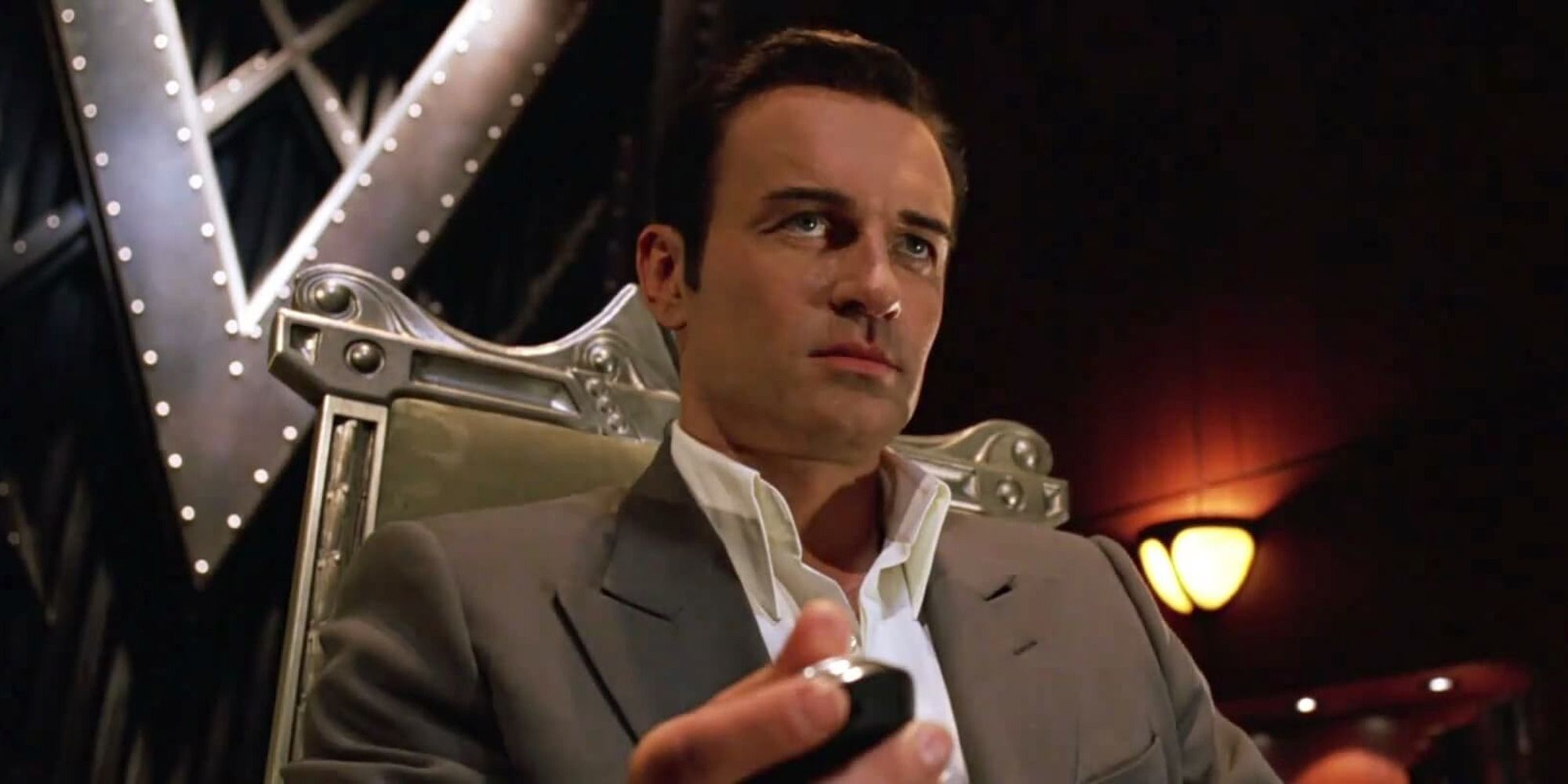 Julian McMahon as Dr. Doom in 'Fantastic Four', sitting in a chair in his office