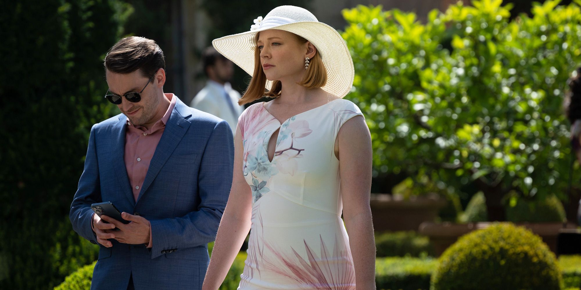 Keiran Culkin with phone and sunglasses and Sarah Snook in white dress and hat in 'Succession'