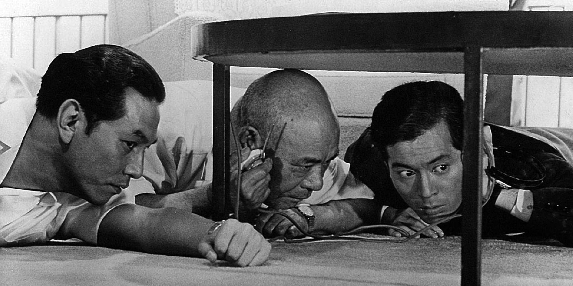 Kenjirô Ishiyama, Takeshi Katô, and Tatsuya Nakadai hiding under a table in High and Low