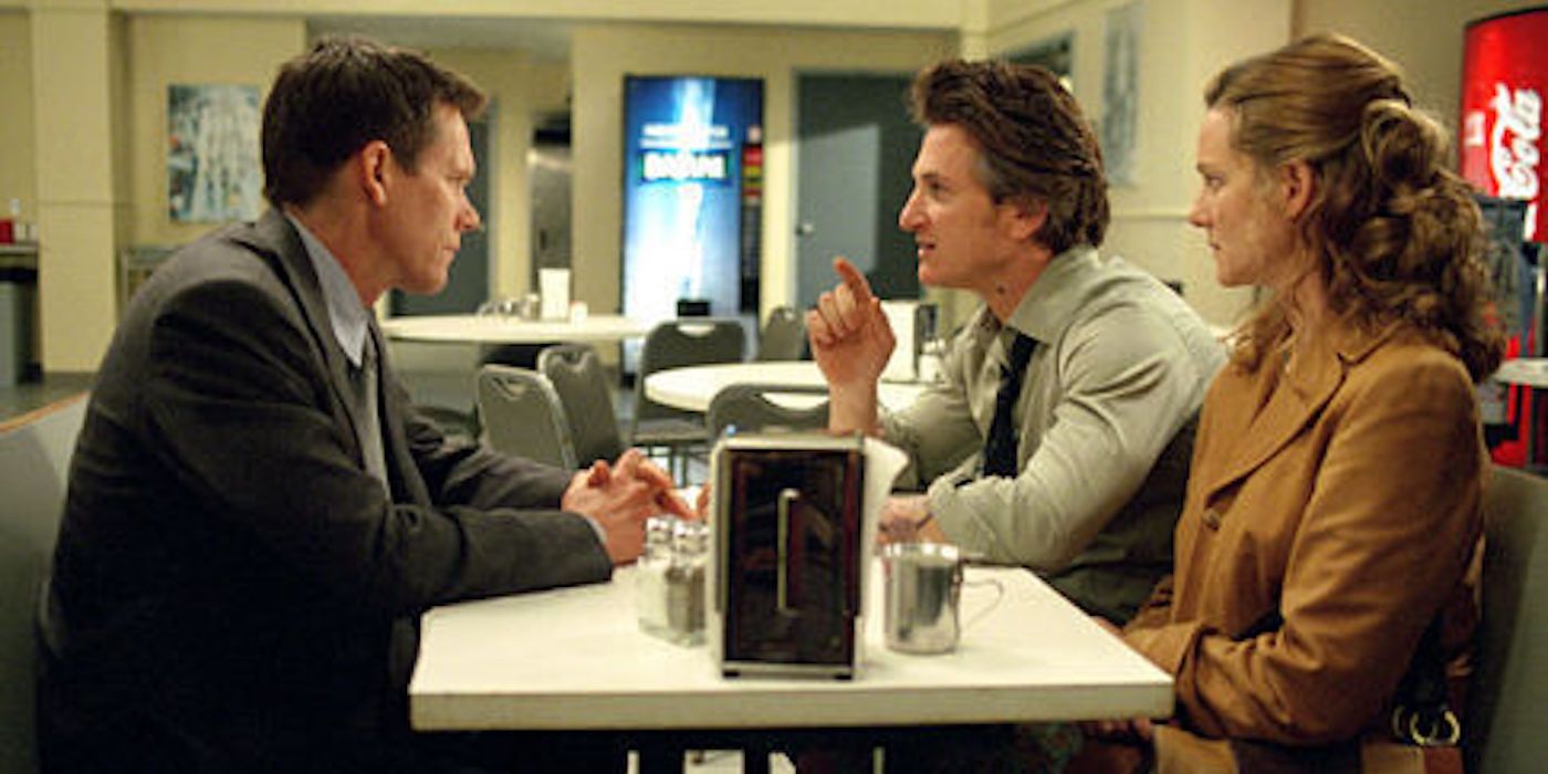 Kevin Bacon, Sean Penn, and Laura Linney sitting at a table in Mystic River