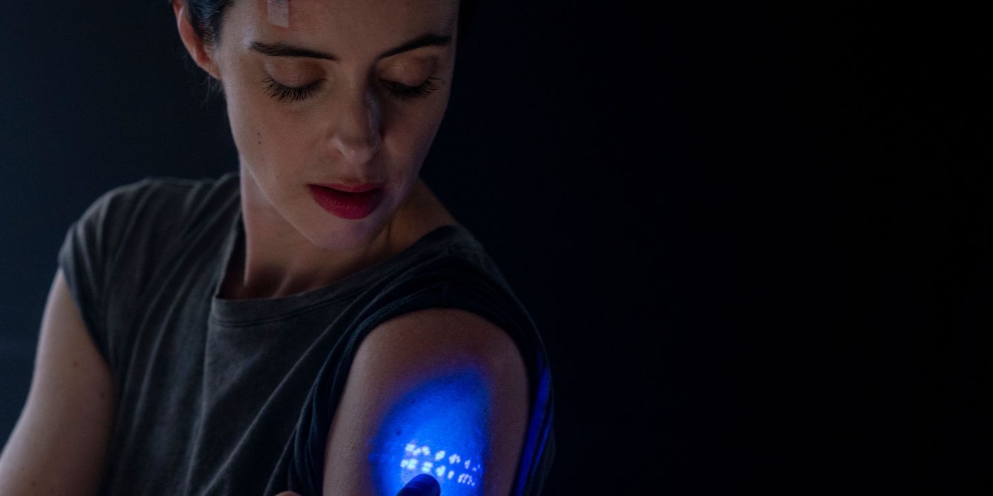 Krysten Ritter as Lucy shining a blacklight on her arm in Orphan Black: Echoes