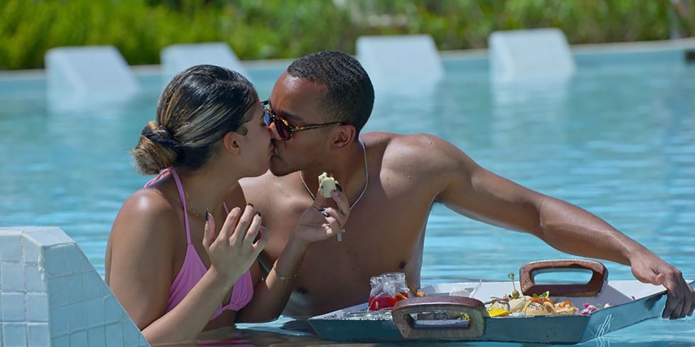 Jackie and Marshall from Love is Blind 4 kissing in the pool, a tray of food in front of them in the water.