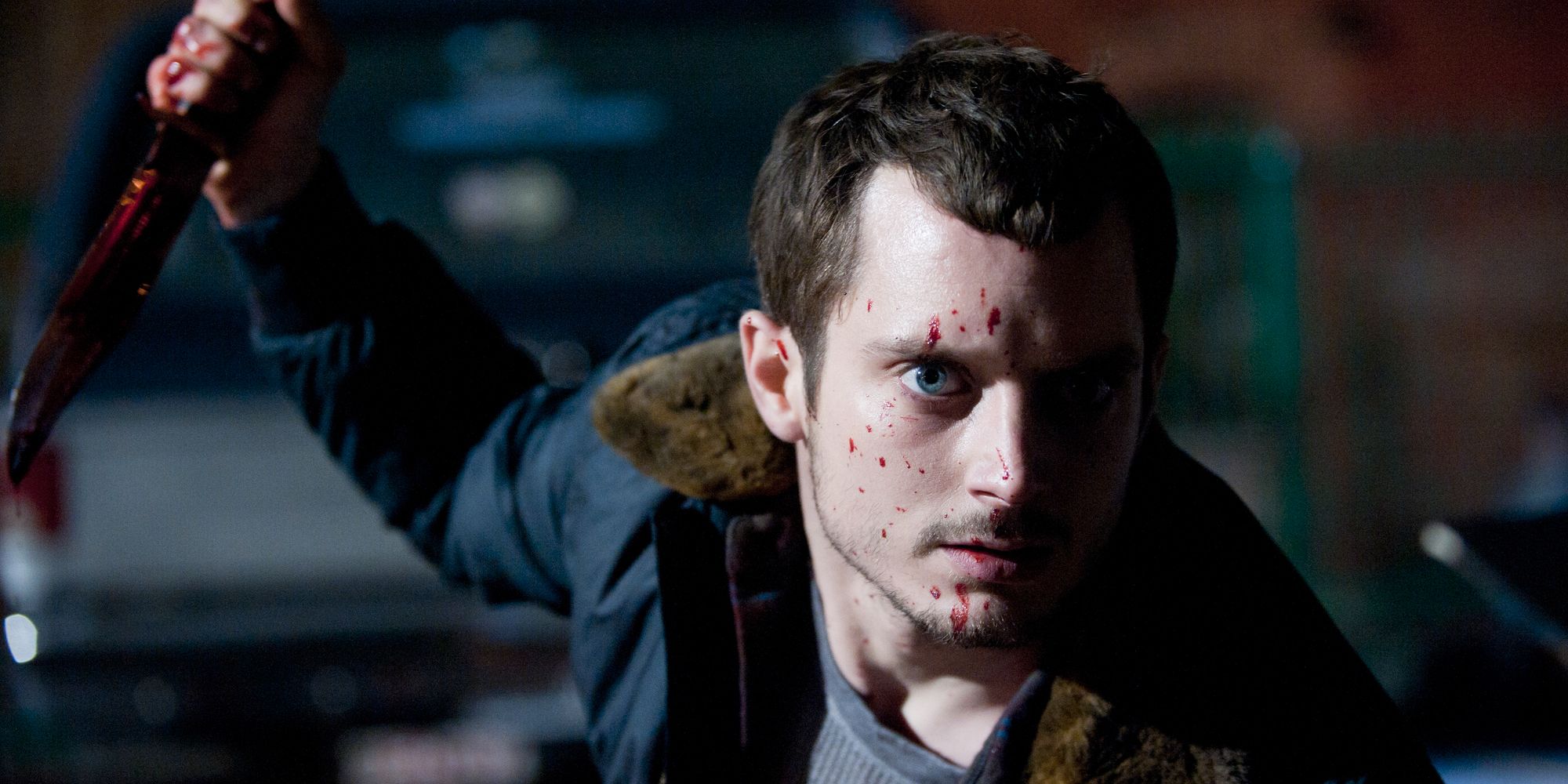 Still from 'Maniac': Frank (Elijah Wood) holds a knife with blood on his face.