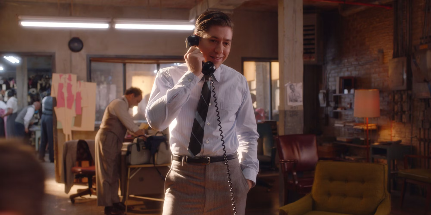 Joel Maisel in The Marvelous Mrs. Maisel in a shirt and tie on the phone, smiling.